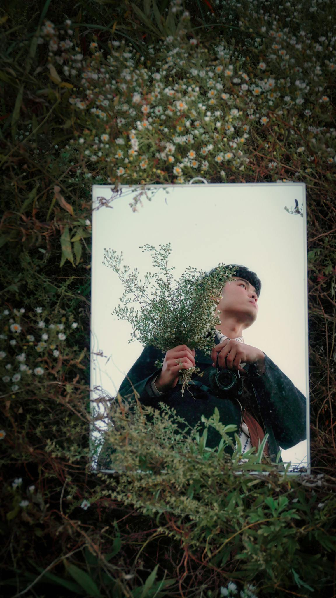 Creative portrait reflection in nature with delicate white flowers and greenery.